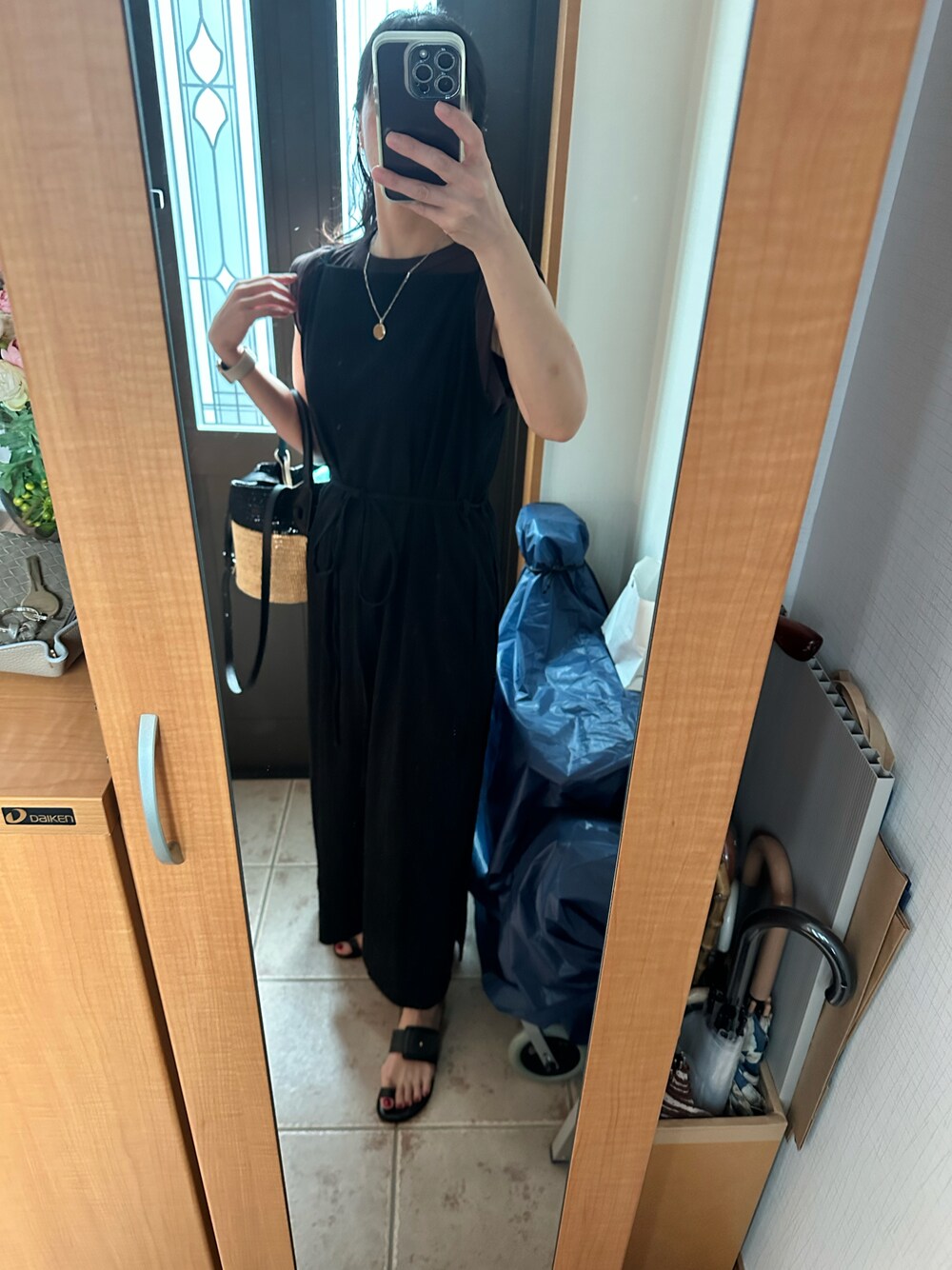 ブラック系のかごバッグ、ブラック系のワンピース、ブラウン系のタンクトップを着用したレディースの夏コーディネートの1枚目の写真