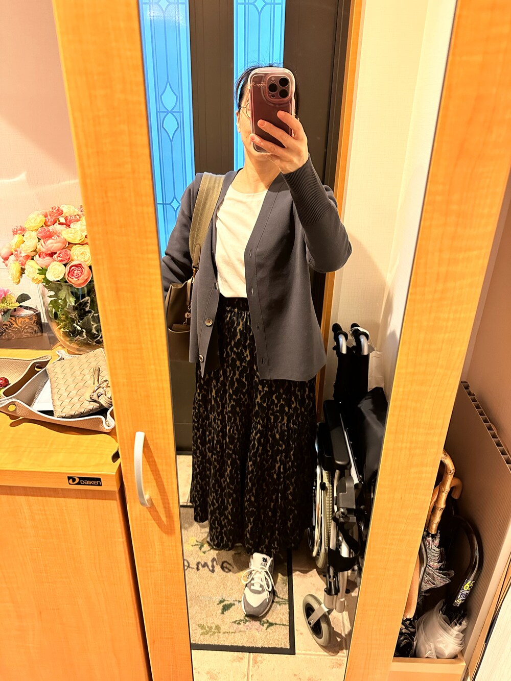 グレー系のカーディガン/ボレロ、ホワイト系のTシャツ/カットソー、グリーン系のスカートを着用したレディースの冬コーディネートの1枚目の写真