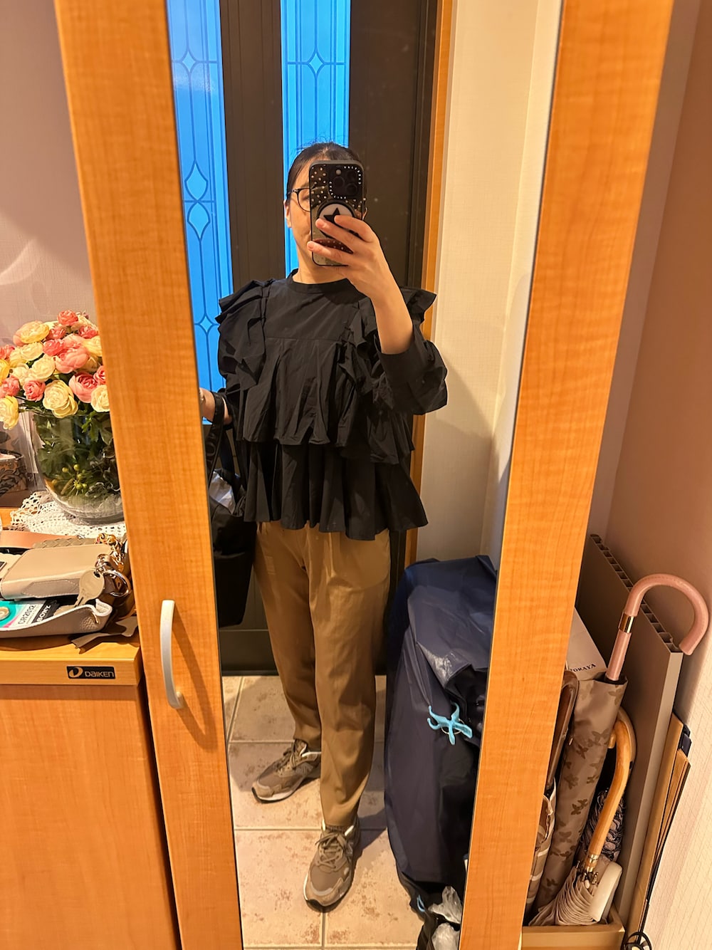 ブラック系のシャツ/ブラウス、イエロー系のその他パンツ、ベージュ系のスニーカーを着用したレディースの秋コーディネートの1枚目の写真