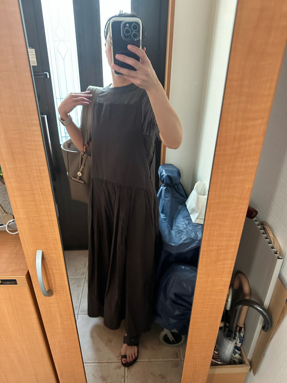 グレー系のワンピース、ブラック系のサンダル、グレー系のTシャツ/カットソーを着用したレディースの夏コーディネートの1枚目の写真