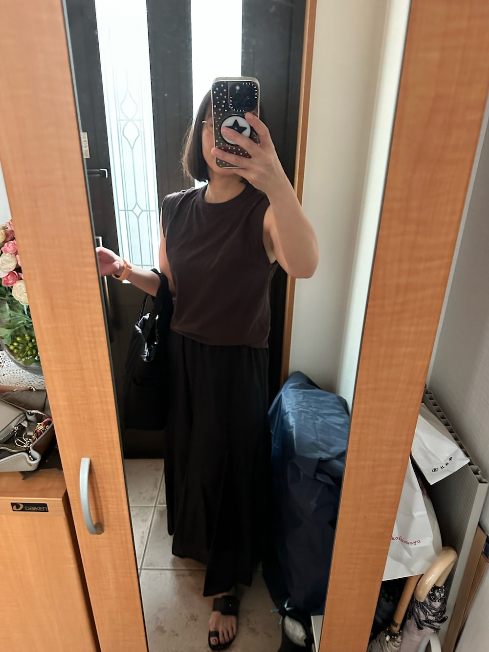 ブラウン系のタンクトップ、ブラック系のスカート、ブラック系のサンダルを着用したレディースの夏コーディネートの1枚目の写真