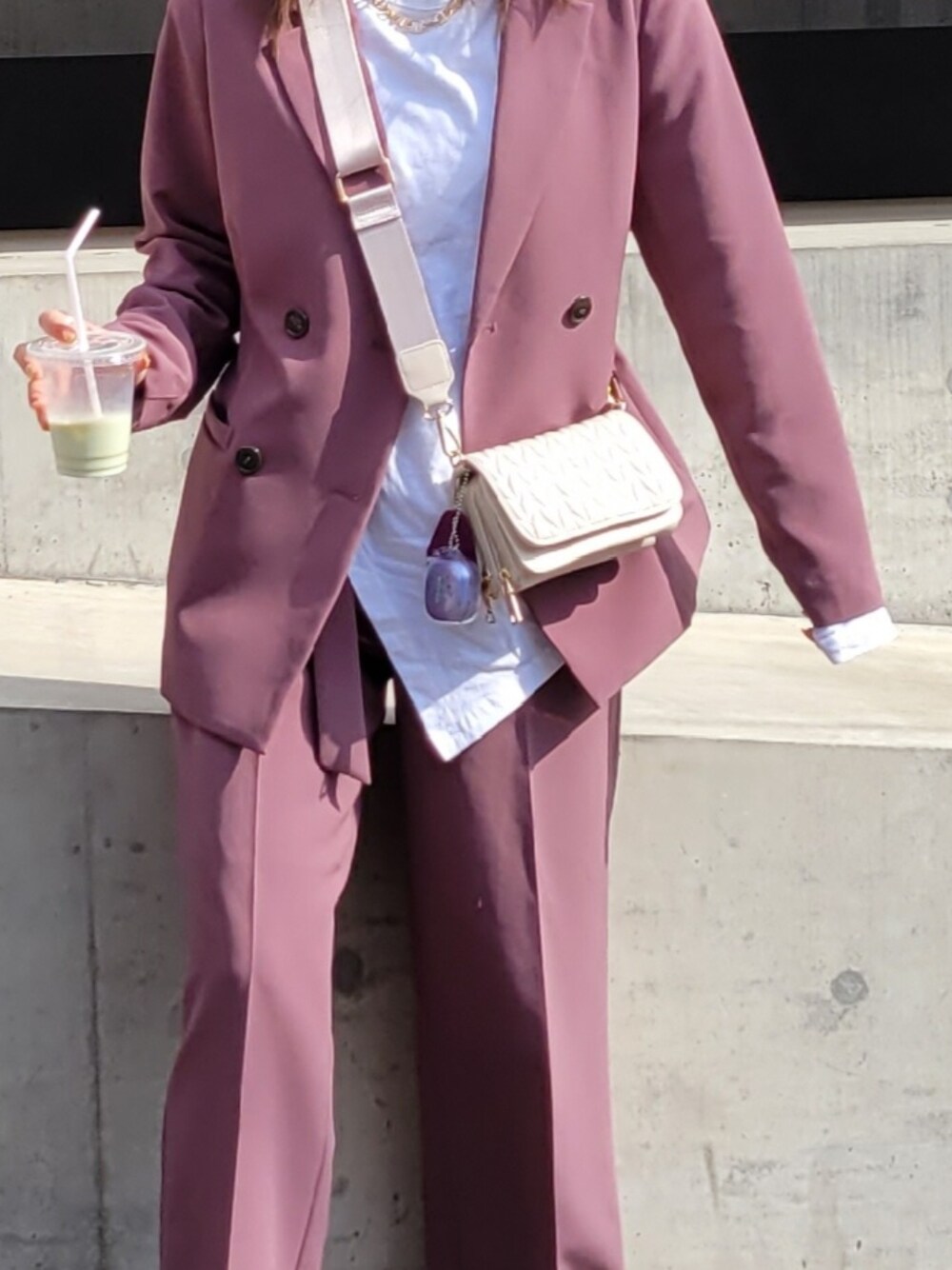 ピンク系のテーラードジャケット、ピンク系のその他パンツ、ベージュ系のショルダーバッグを着用したレディースの春コーディネートの2枚目の写真