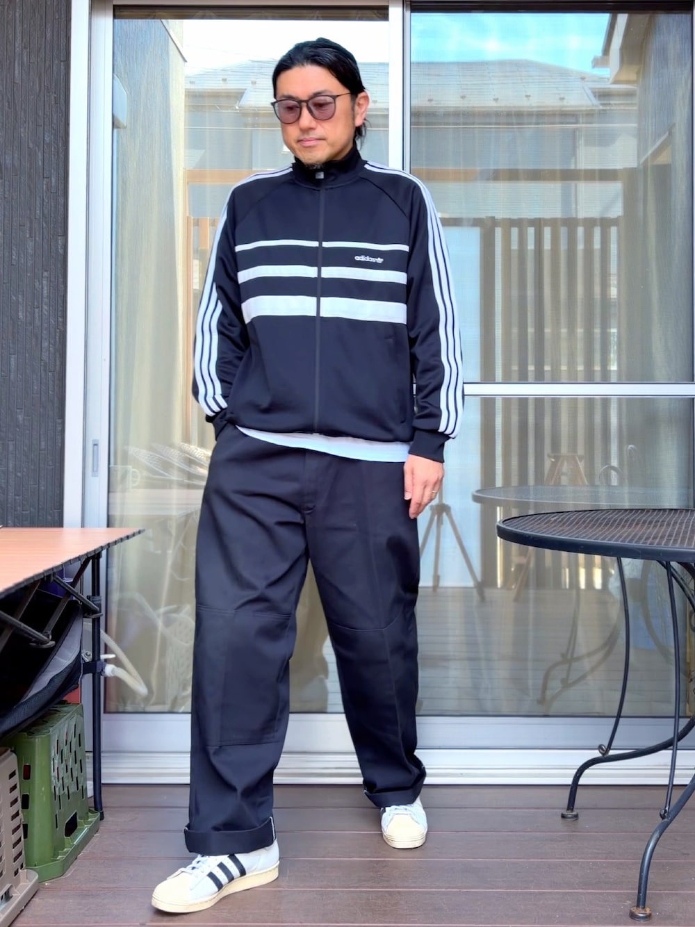 ブラック系のチノパンツ、ブラック系のジャージ、ホワイト系のスニーカーを着用したメンズの春コーディネートの1枚目の写真