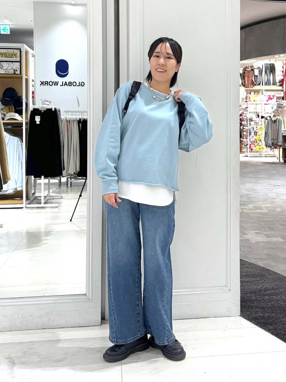 ブラック系のバックパック/リュック、ホワイト系のTシャツ/カットソー、ブルー系のデニムパンツを着用したレディースの秋コーディネートの1枚目の写真