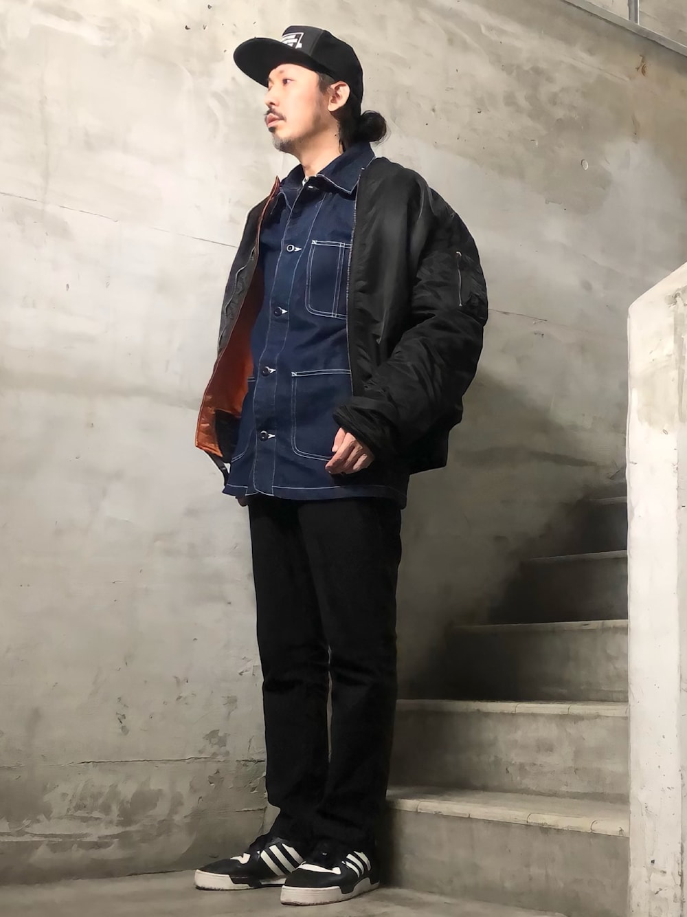 ブラック系のMA-1、ブラック系のチノパンツ、ブラック系のスニーカーを着用したメンズの冬コーディネートの1枚目の写真