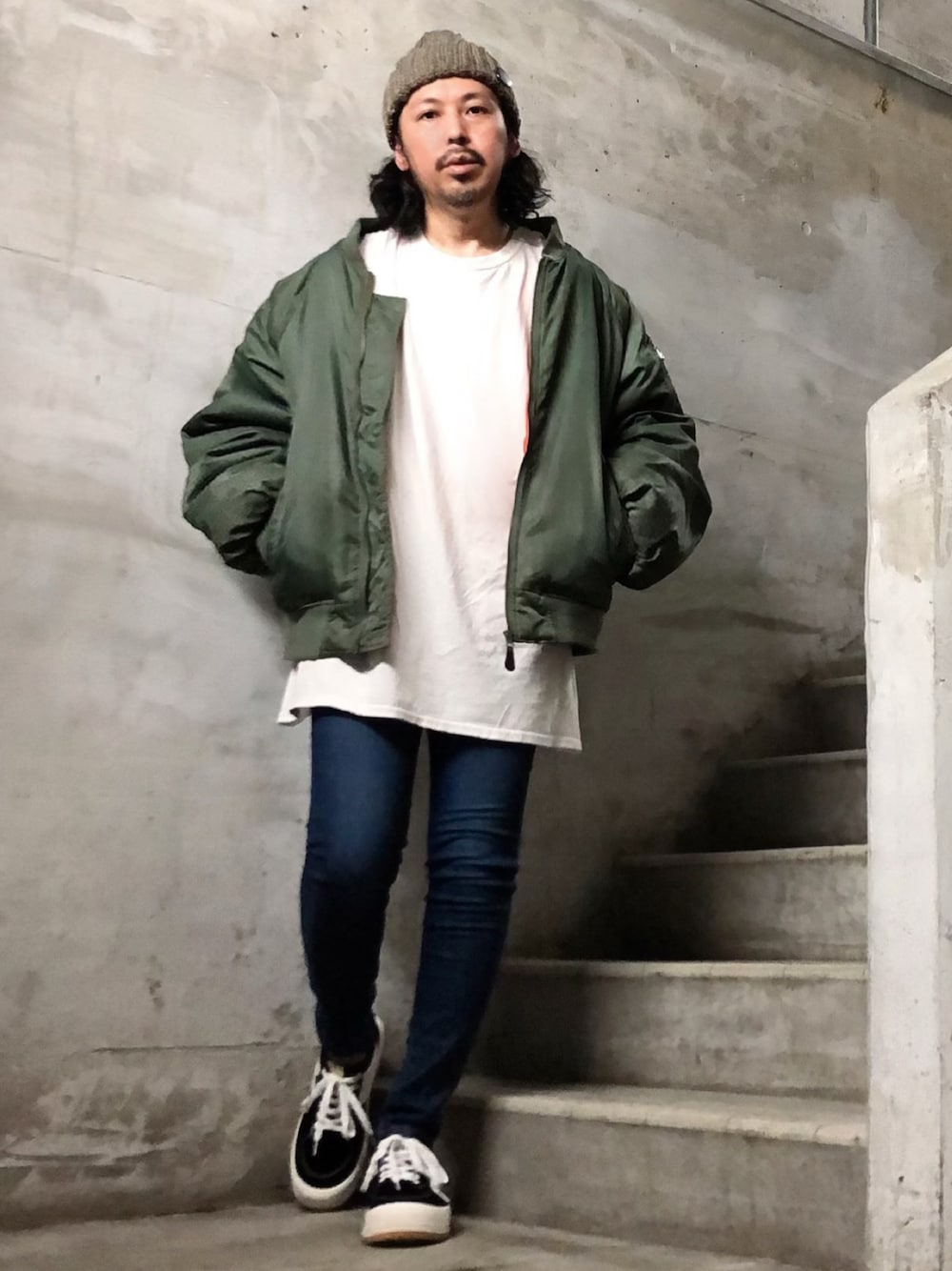 ブルー系のデニムパンツ、ブラック系のスニーカー、ホワイト系のTシャツ/カットソーを着用したメンズの秋コーディネートの1枚目の写真