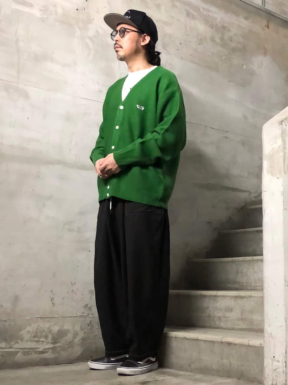 グリーン系のカーディガン/ボレロ、ブラック系のその他パンツ、ブラック系のスニーカーを着用したメンズの秋コーディネートの1枚目の写真