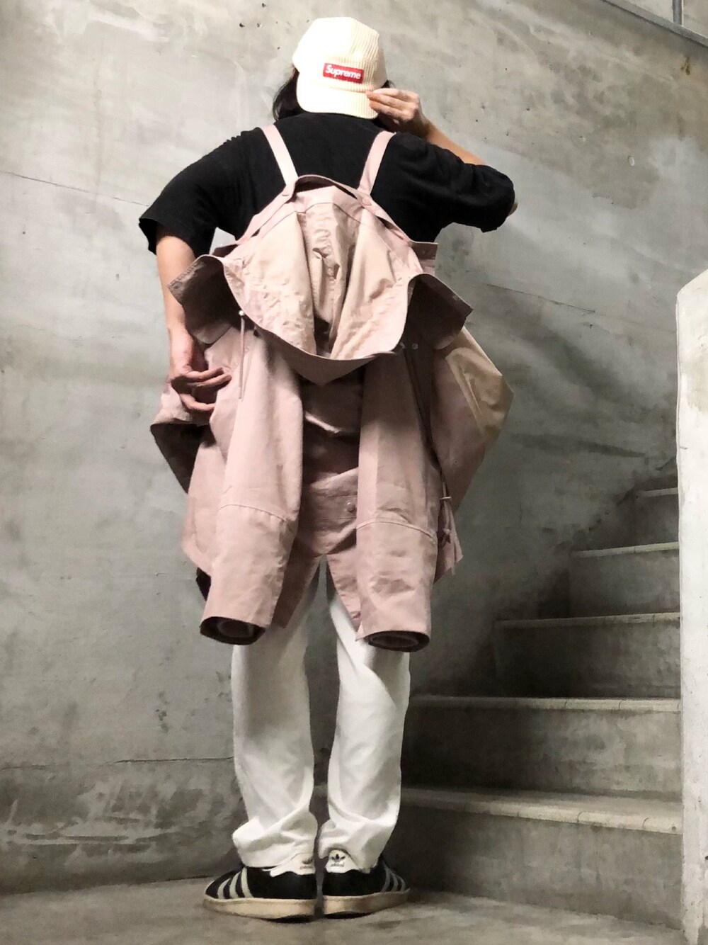 ピンク系のモッズコート、ブラック系のTシャツ/カットソー、ブラック系のスニーカーを着用したメンズの春コーディネートの1枚目の写真