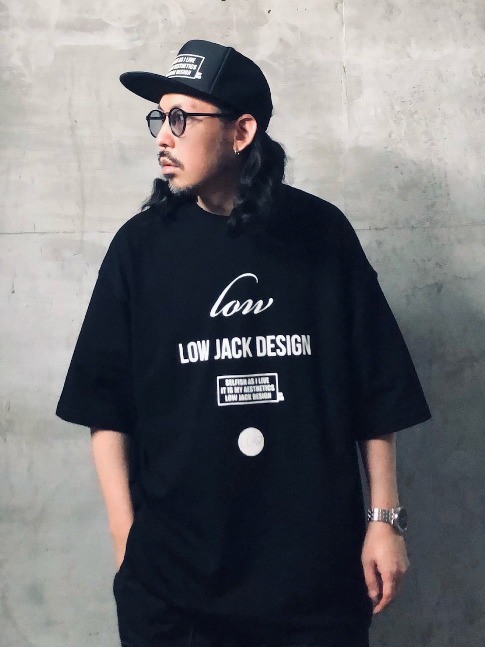 ブラック系のTシャツ/カットソー、ブラック系のキャップを着用したメンズの夏コーディネートの1枚目の写真