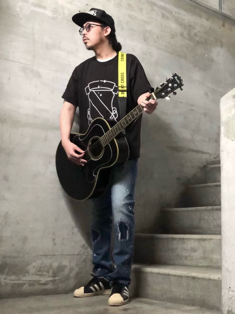 ブラック系のTシャツ/カットソー、ブルー系のデニムパンツ、ブラック系のスニーカーを着用したメンズの春コーディネートの1枚目の写真