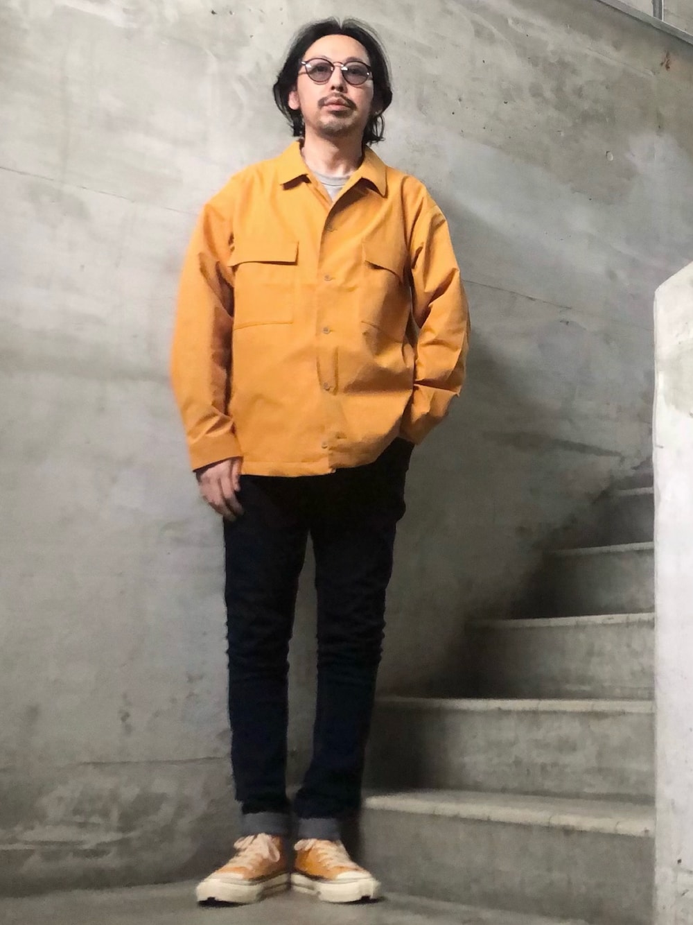 イエロー系のミリタリージャケット、グレー系のスウェット、イエロー系のスニーカーを着用したメンズの冬コーディネートの1枚目の写真