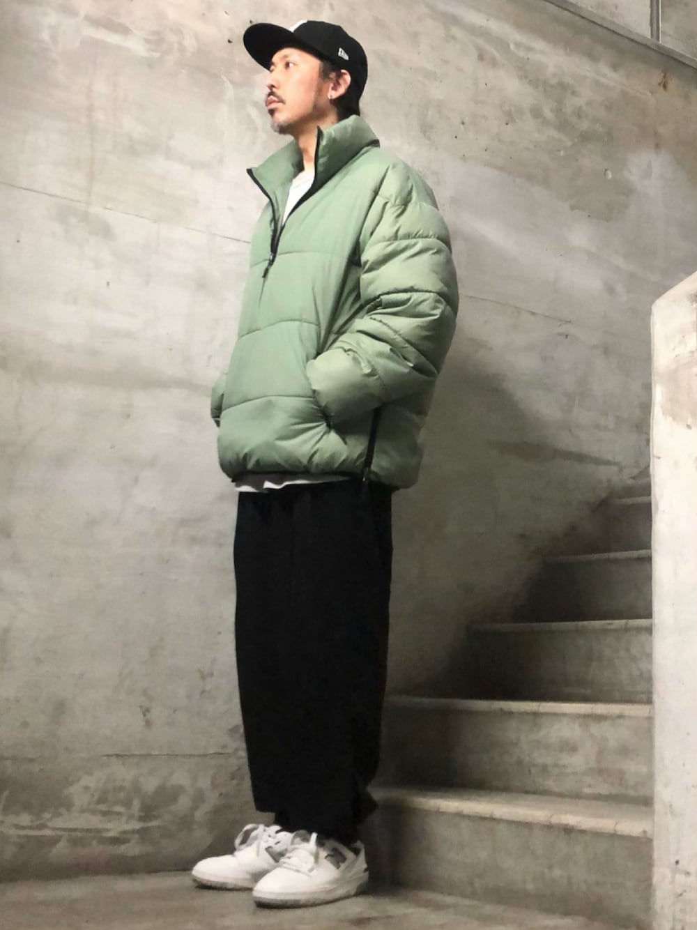 グリーン系のダウンジャケット/コート、グレー系のTシャツ/カットソー、ブラック系のその他パンツを着用したメンズの冬コーディネートの1枚目の写真