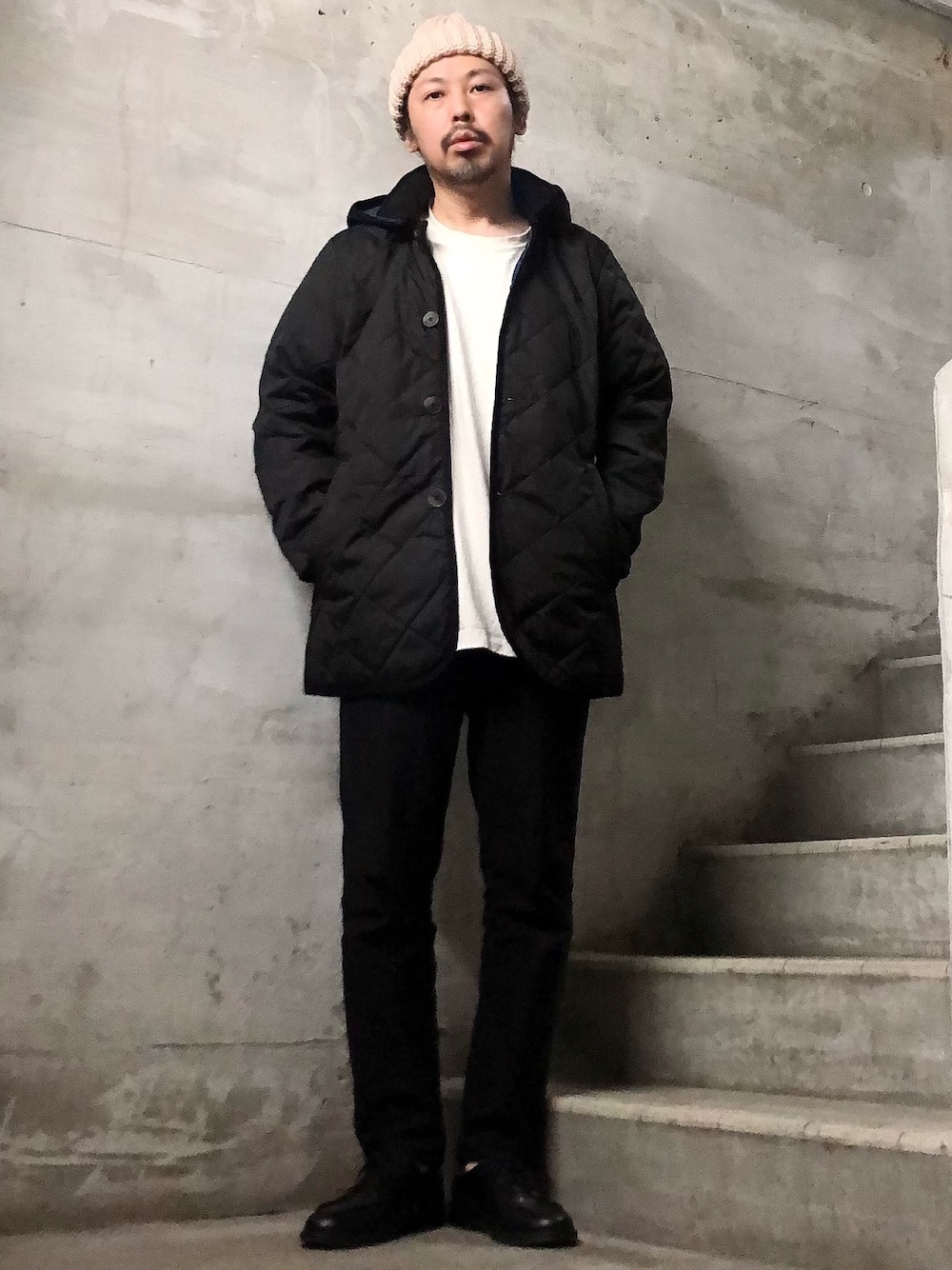 ブラック系のダウンジャケット/コート、ブラック系のチノパンツ、ブラック系のブーツを着用したメンズの冬コーディネートの1枚目の写真