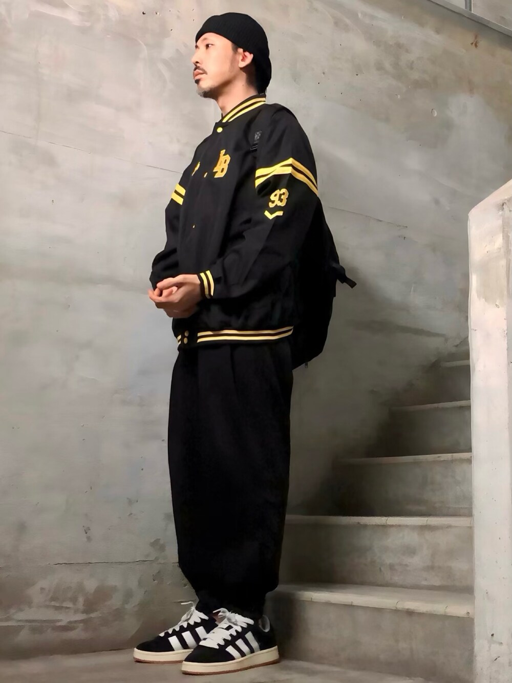 ブラック系のスタジャン、ブラック系のその他パンツ、ブラック系のスニーカーを着用したメンズの秋コーディネートの1枚目の写真