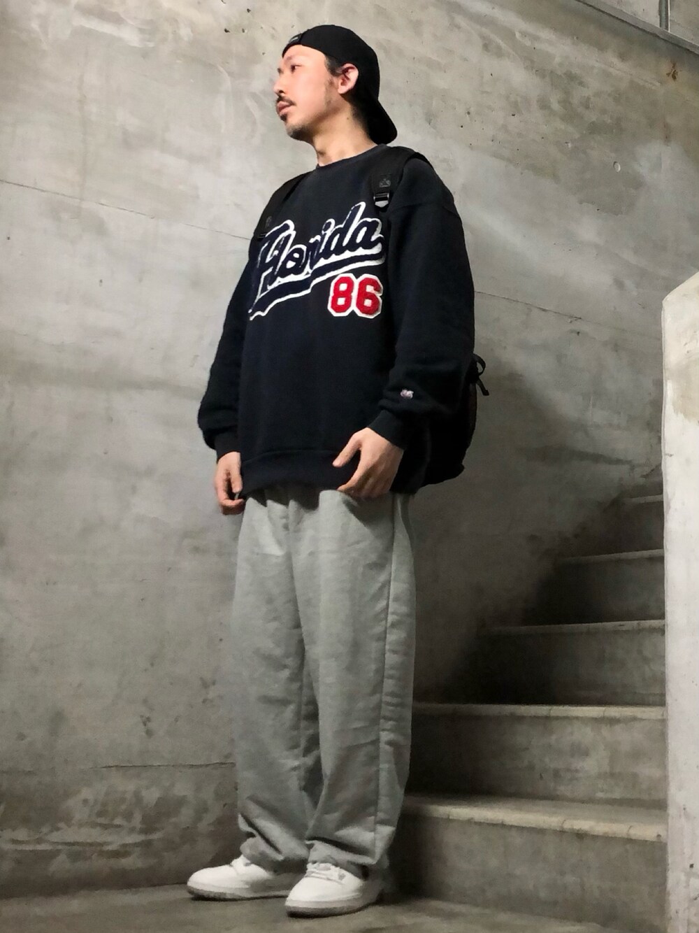ブルー系のスウェット、その他のスウェットパンツ、ホワイト系のスニーカーを着用したメンズの冬コーディネートの1枚目の写真