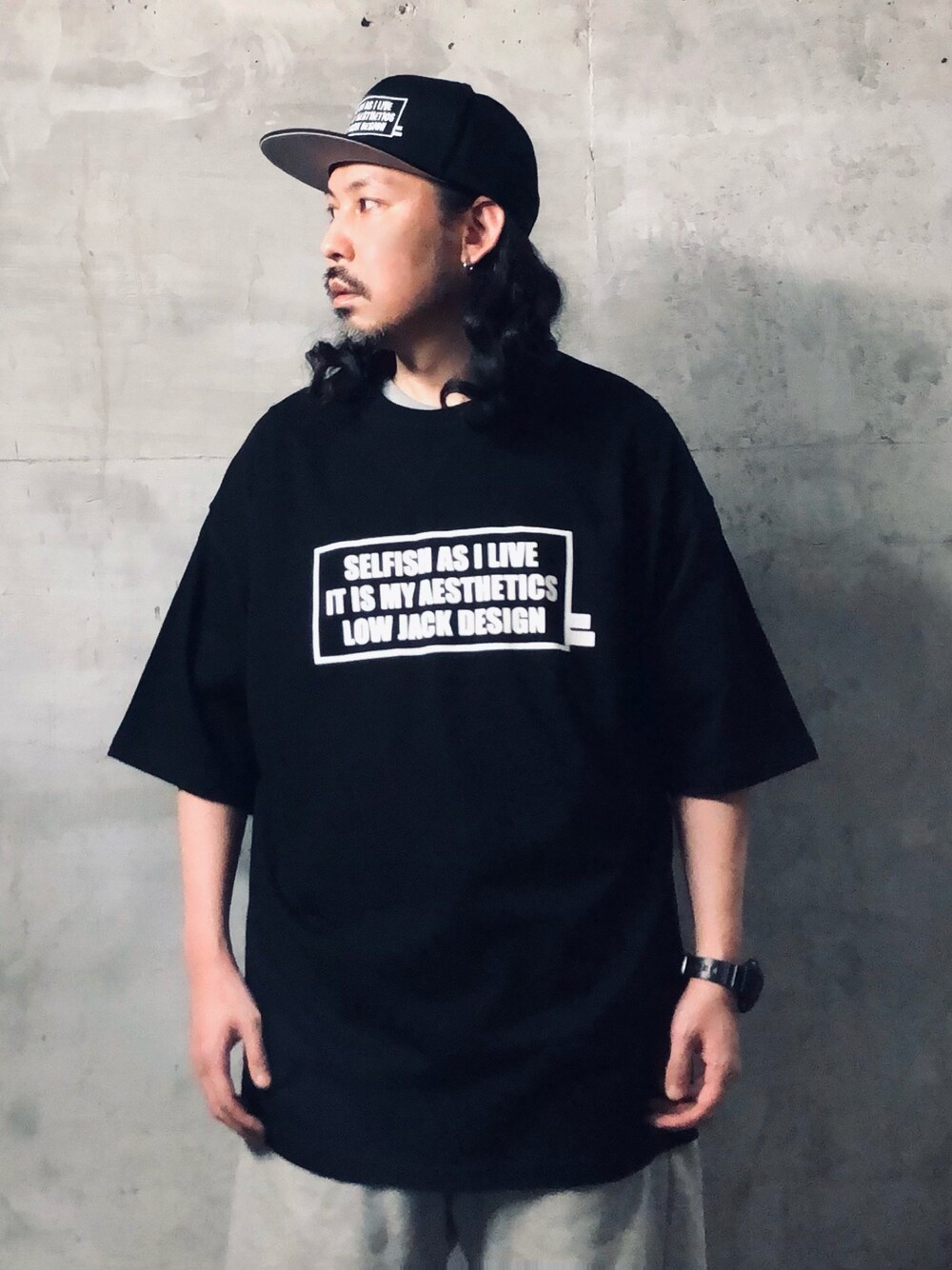 ブラック系のTシャツ/カットソー、ブラック系のキャップを着用したメンズの夏コーディネートの1枚目の写真