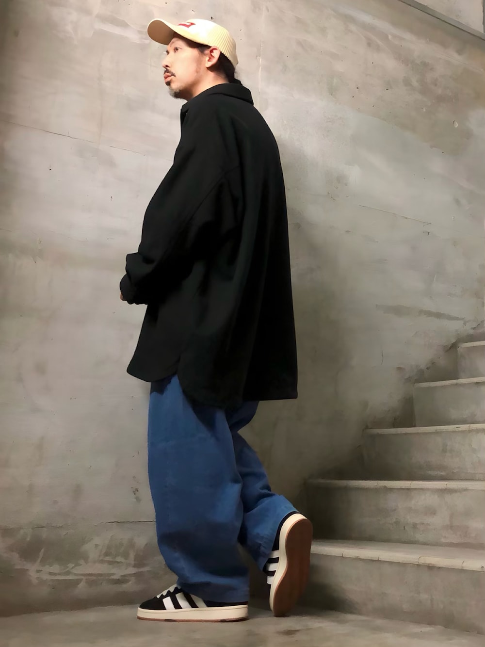 ブラック系のデニムパンツ、ブラック系のスニーカー、ブラック系のブルゾンを着用したメンズの秋コーディネートの1枚目の写真