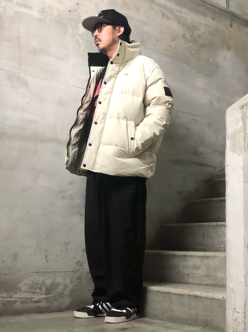 ホワイト系のダウンジャケット/コート、ブラック系のスウェット、ブラック系のスニーカーを着用したメンズの秋コーディネートの1枚目の写真