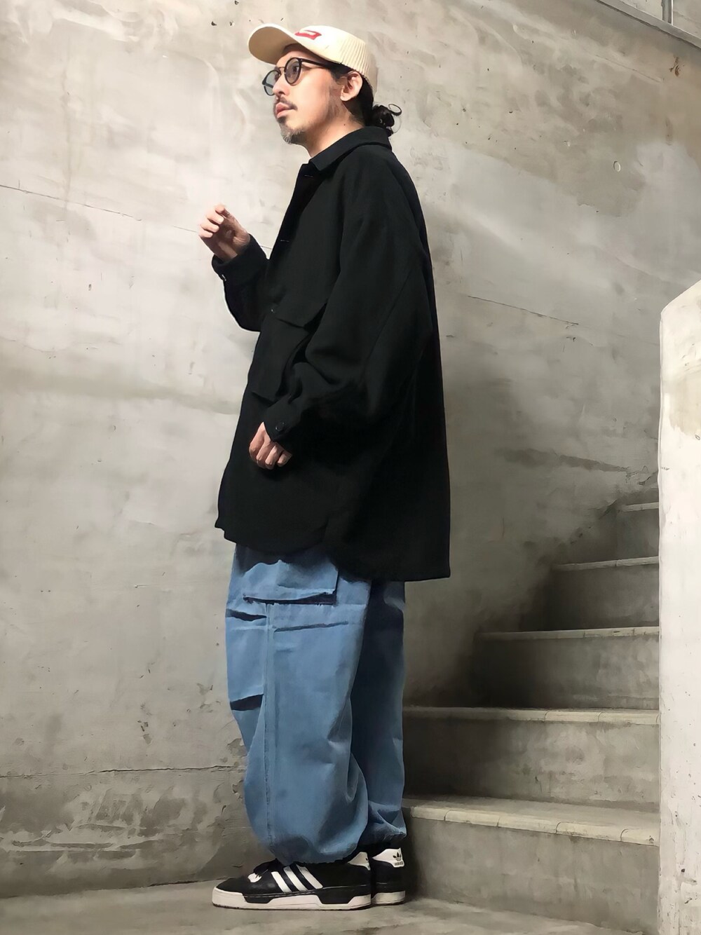 ブルー系のデニムパンツ、ブラック系のブルゾン、ブラック系のスニーカーを着用したメンズの秋コーディネートの1枚目の写真