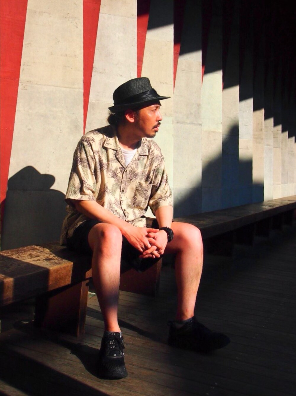 グリーン系のシャツ/ブラウス、ブラック系のスニーカー、ブラック系のハットを着用したメンズの春コーディネートの1枚目の写真