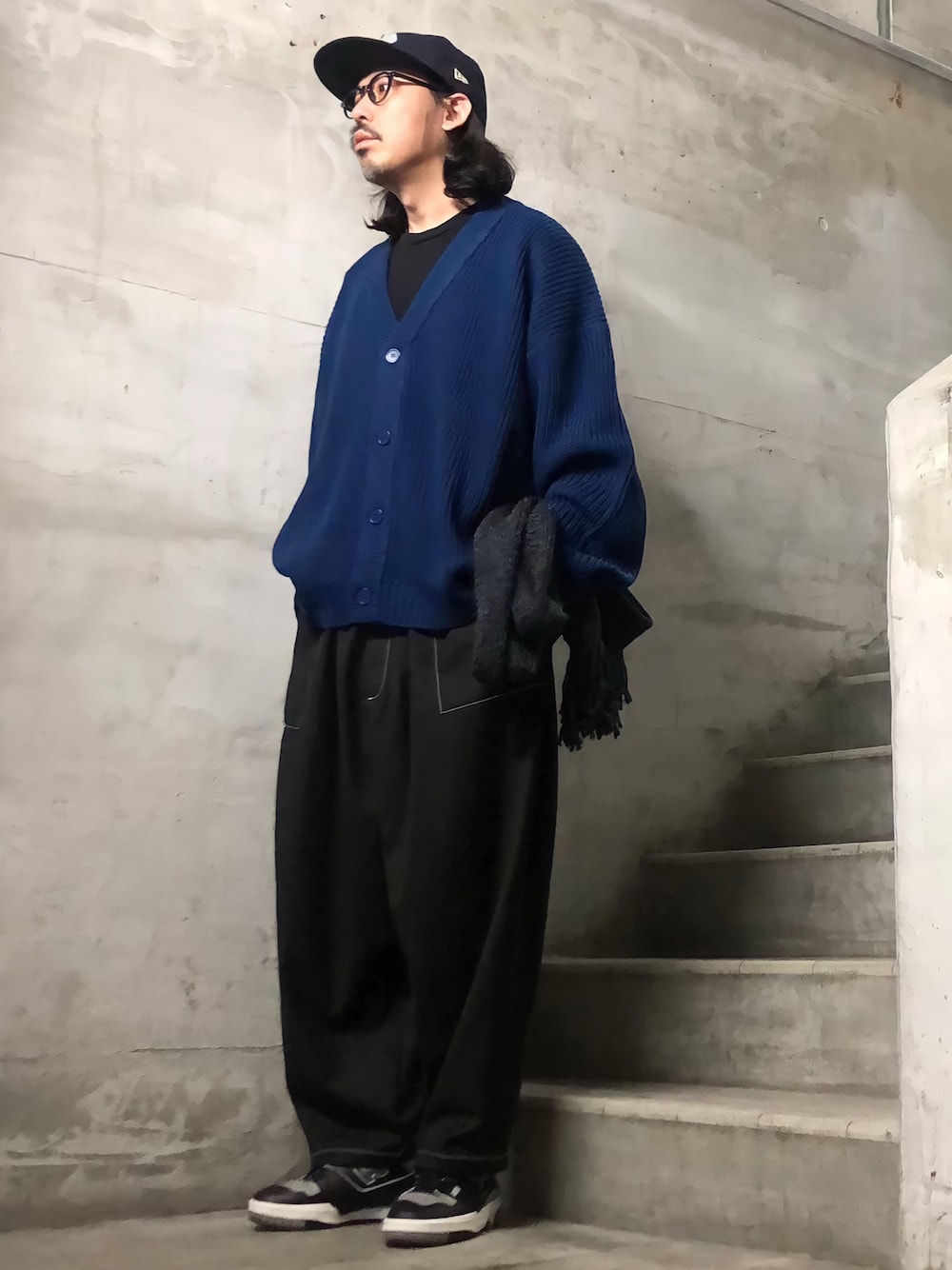 ブルー系のカーディガン/ボレロ、ブラック系のスニーカー、ブラック系のキャップを着用したメンズの冬コーディネートの1枚目の写真