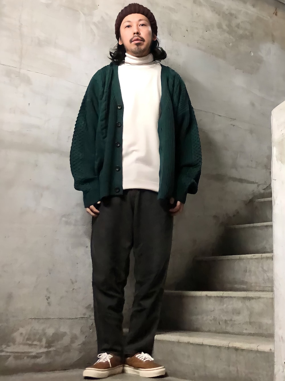 グリーン系のカーディガン/ボレロ、ブラック系のデニムパンツ、ブラウン系のスニーカーを着用したメンズの冬コーディネートの1枚目の写真