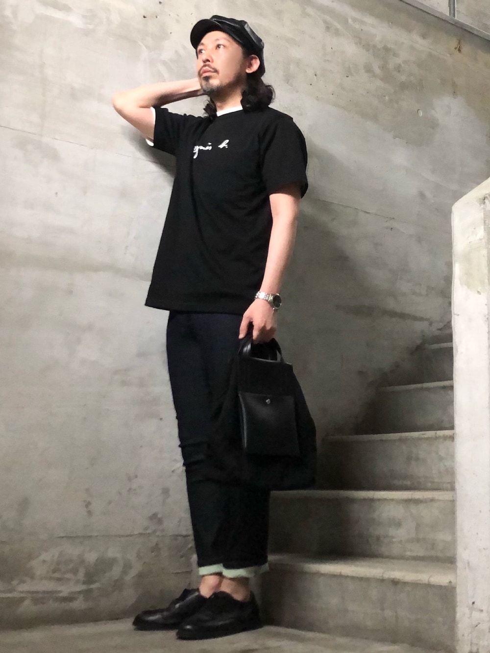 ブラック系のTシャツ/カットソー、ブラック系のショルダーバッグ、ブルー系のデニムパンツを着用したメンズの春コーディネートの1枚目の写真