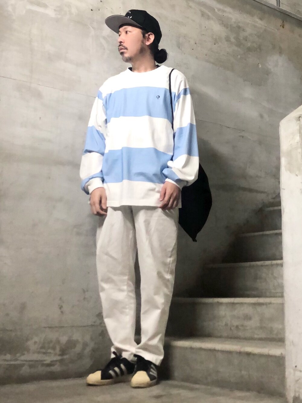 ブルー系のTシャツ/カットソー、ブラック系のスニーカー、ブラック系のキャップを着用したメンズの夏コーディネートの1枚目の写真