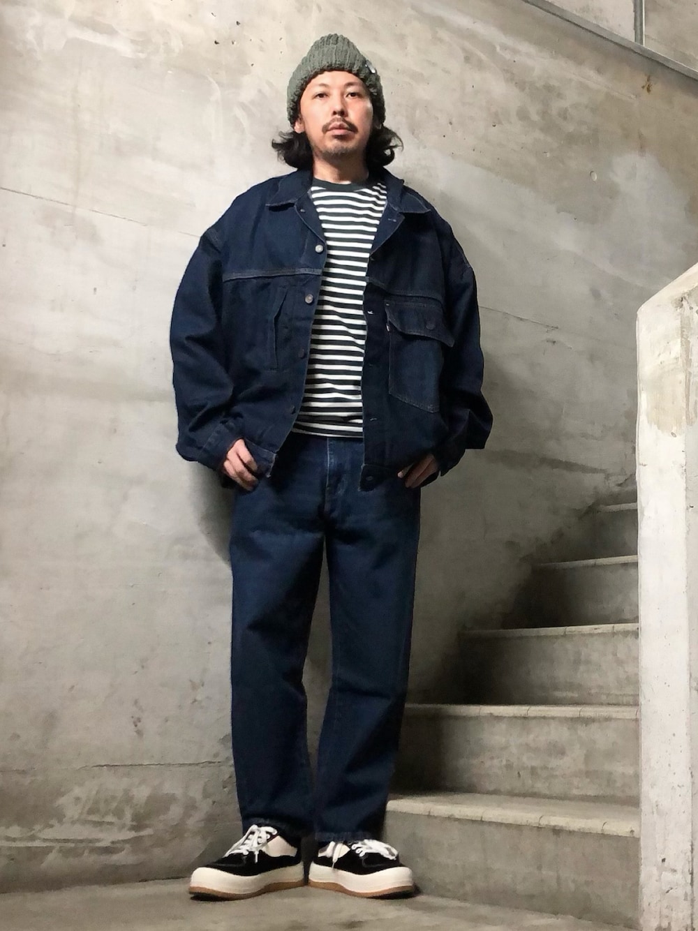 ブラック系のスニーカー、ブルー系のデニムパンツ、ブルー系のデニムジャケットを着用したメンズの夏コーディネートの1枚目の写真