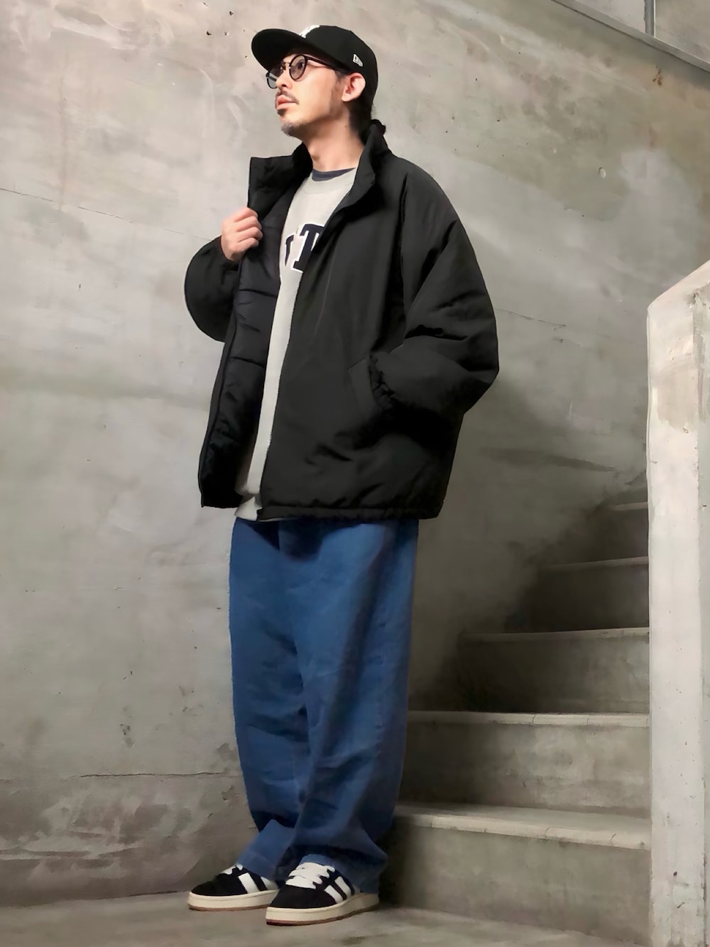グレー系のスウェット、ブラック系のスニーカー、ブラック系のダウンジャケット/コートを着用したメンズの秋コーディネートの1枚目の写真