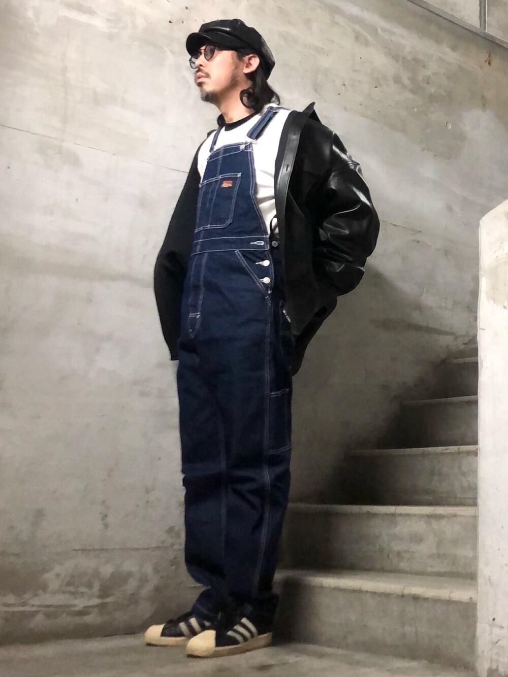 ブルー系のサロペット/オーバーオール、ブラック系のシャツ/ブラウス、ブラック系のスニーカーを着用したメンズの冬コーディネートの1枚目の写真