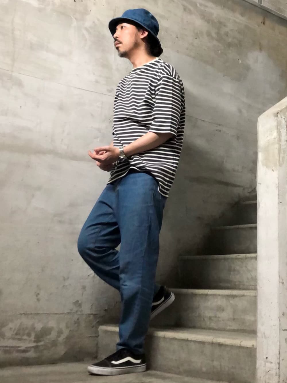 ホワイト系のTシャツ/カットソー、ブラック系のスニーカー、ブルー系のハットを着用したメンズの夏コーディネートの1枚目の写真