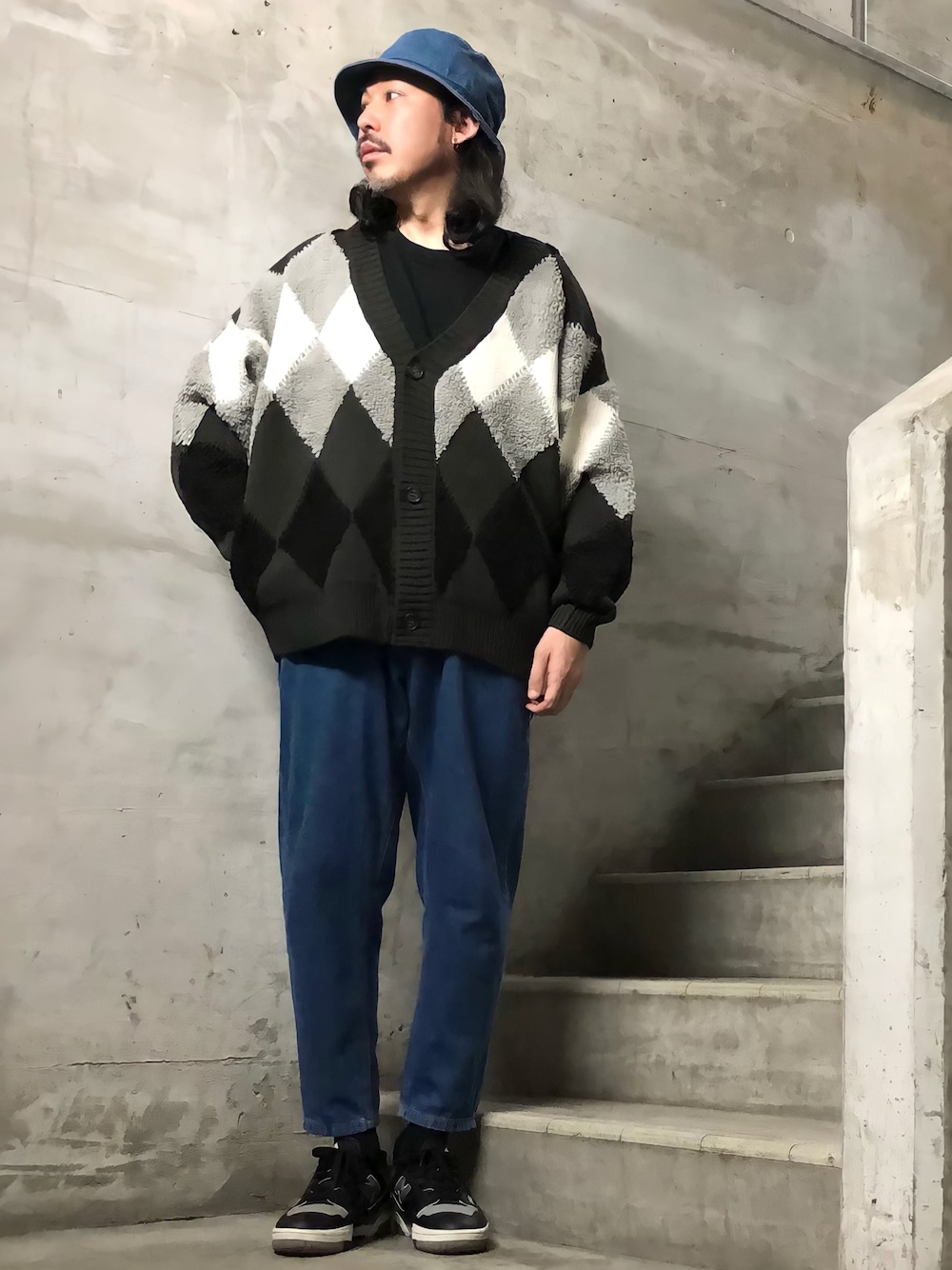 ブラック系のカーディガン/ボレロ、ブラック系のスニーカー、ブルー系のハットを着用したメンズの冬コーディネートの1枚目の写真