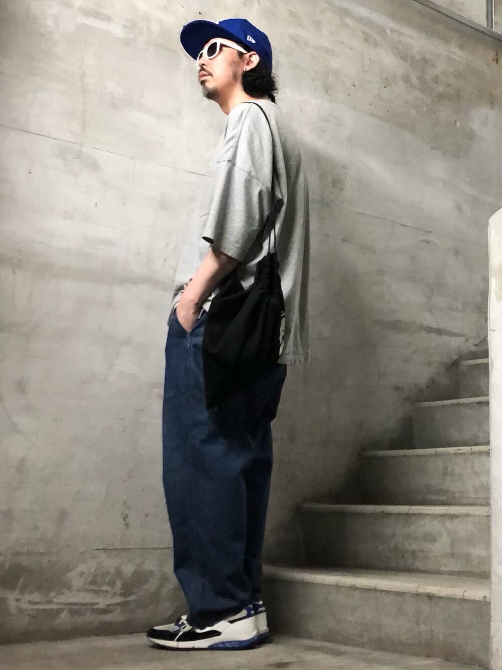 グレー系のTシャツ/カットソー、ブルー系のデニムパンツ、ホワイト系のスニーカーを着用したメンズの夏コーディネートの1枚目の写真