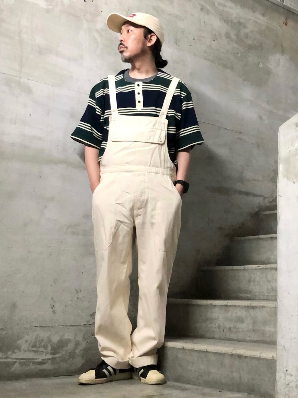 ホワイト系のサロペット/オーバーオール、ブラック系のスニーカー、グリーン系のTシャツ/カットソーを着用したメンズの夏コーディネートの1枚目の写真