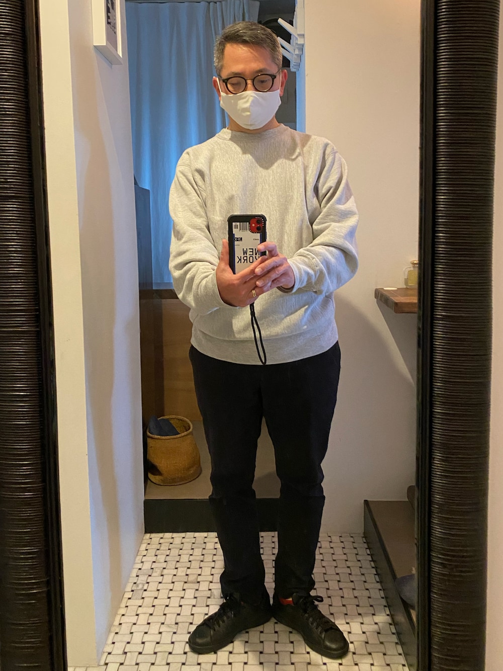 グレー系のスウェット、ブラック系のチノパンツ、ブラック系のスニーカーを着用したメンズの春コーディネートの1枚目の写真