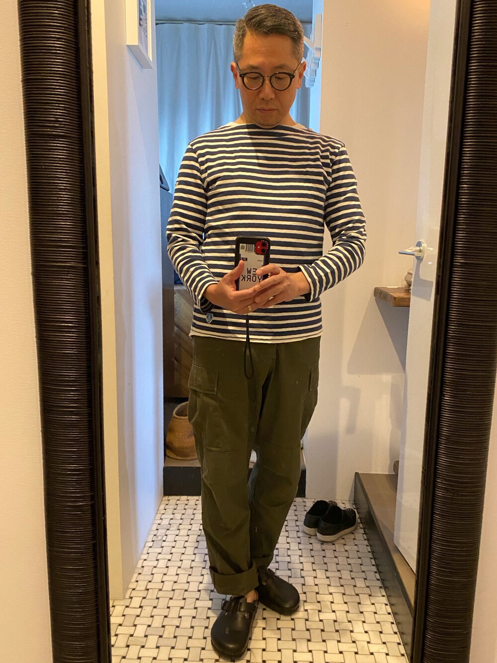 グリーン系のカーゴパンツ、ブルー系のTシャツ/カットソー、ブラック系のサンダルを着用したメンズの春コーディネートの1枚目の写真