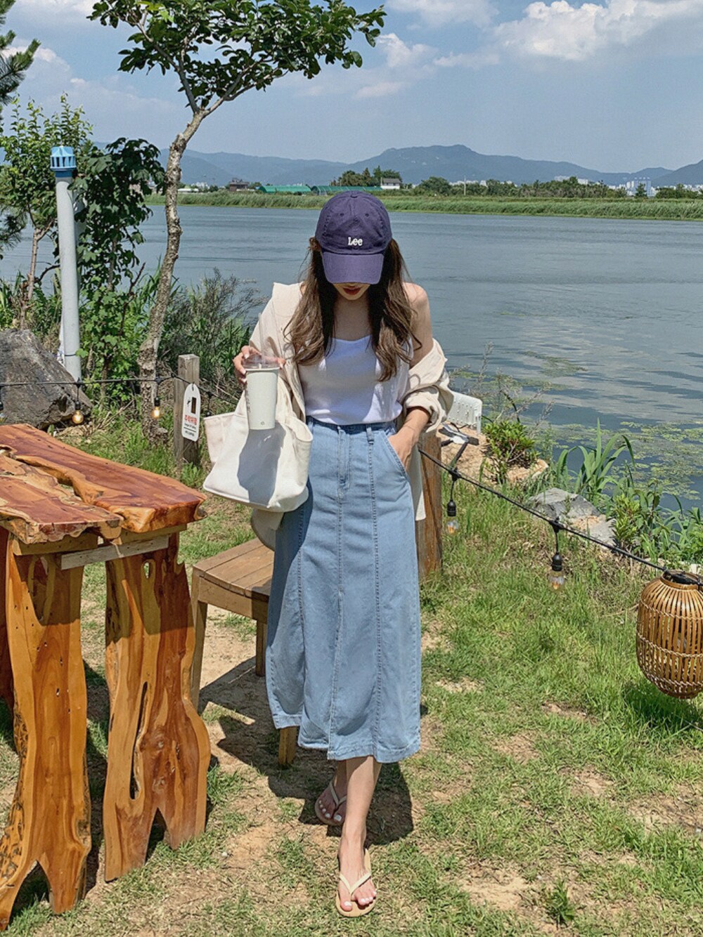 ブルー系のデニムスカートを着用したレディースの夏コーディネートの1枚目の写真
