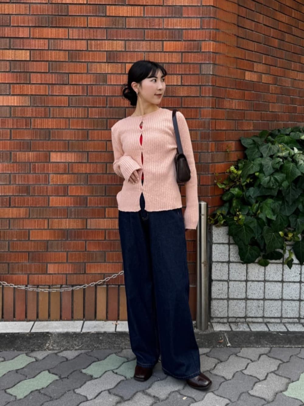 レッド系のタンクトップ、ブルー系のデニムパンツ、ピンク系のカーディガン/ボレロを着用したレディースの秋コーディネートの1枚目の写真