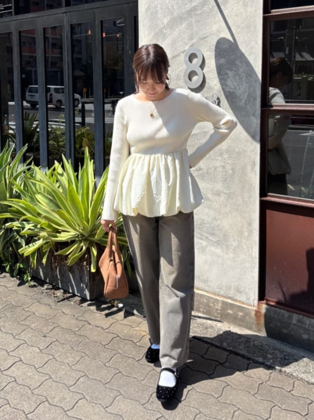 ブルー系のデニムパンツ、ブラック系のバレエシューズ、ホワイト系のニット/セーターを着用したレディースの秋コーディネートの1枚目の写真