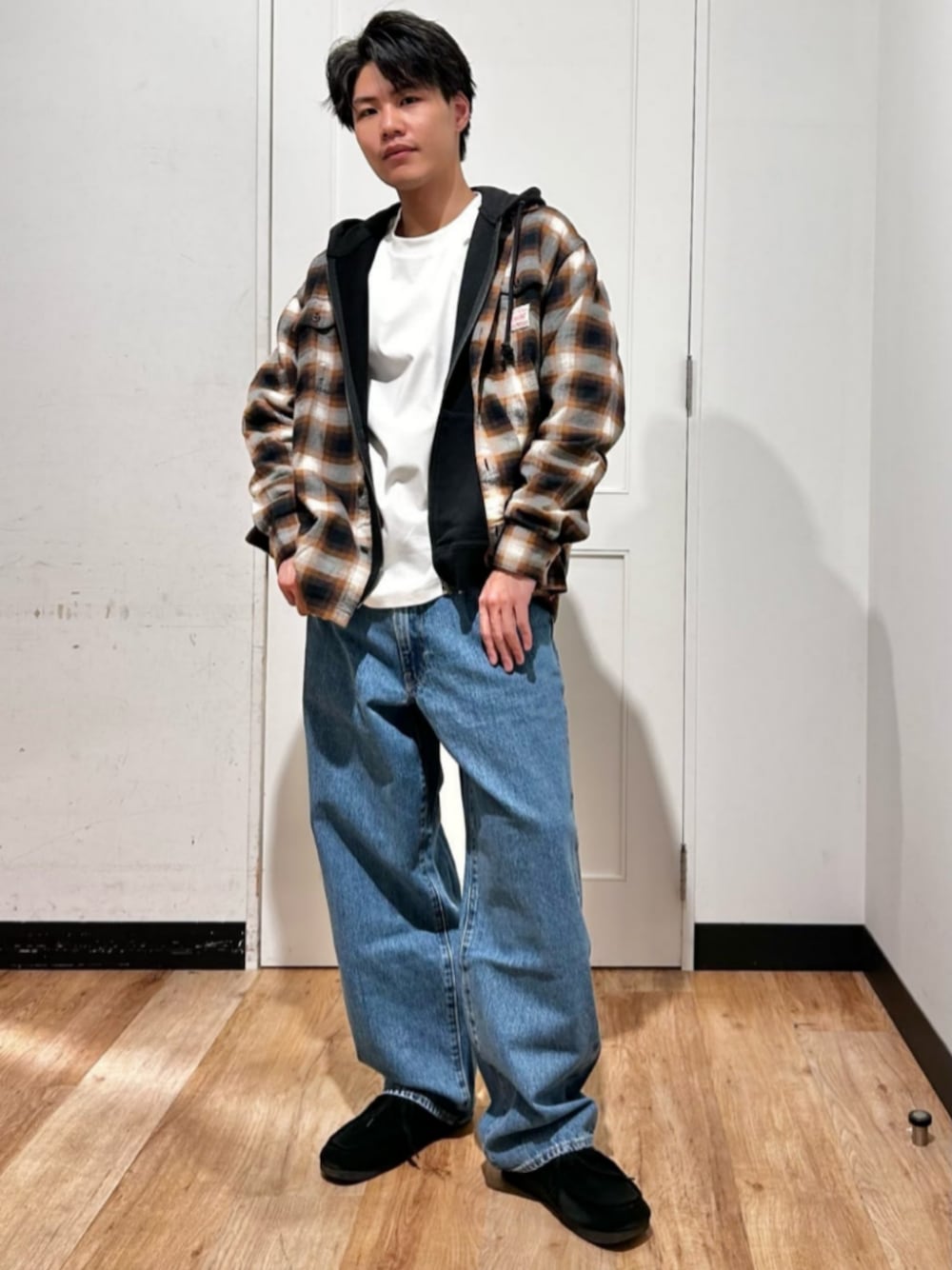 ホワイト系のTシャツ/カットソー、ブラック系のパーカー、ブルー系のデニムパンツを着用したメンズの冬コーディネートの1枚目の写真