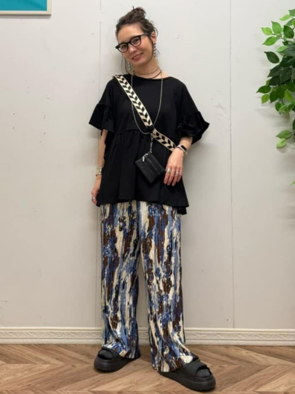 ブラック系のその他トップス、ホワイト系のその他パンツ、ブラック系のサンダルを着用したレディースの夏コーディネートの1枚目の写真