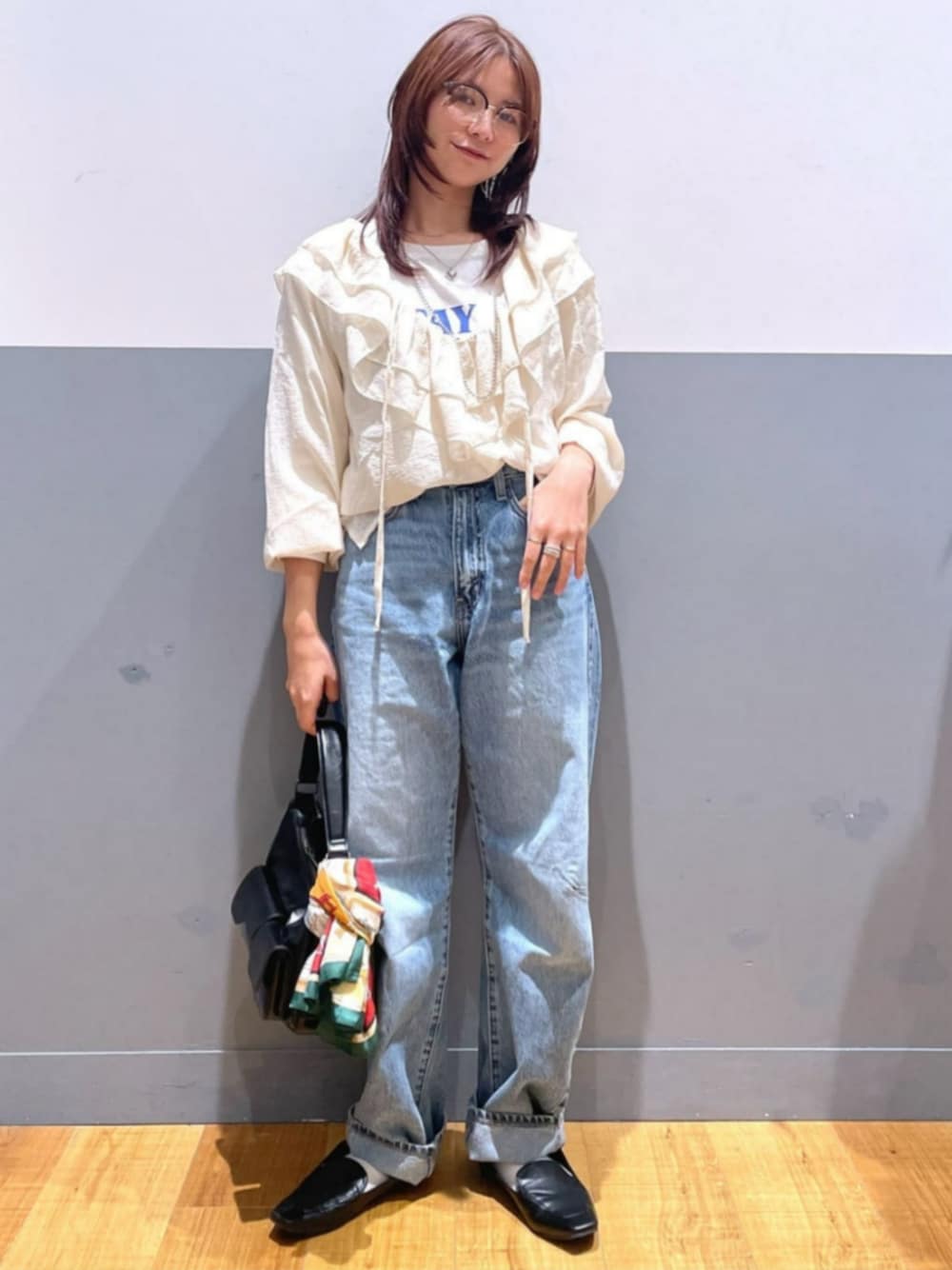 ブラック系のショルダーバッグ、ホワイト系のTシャツ/カットソー、ブルー系のデニムパンツを着用したレディースの秋コーディネートの1枚目の写真