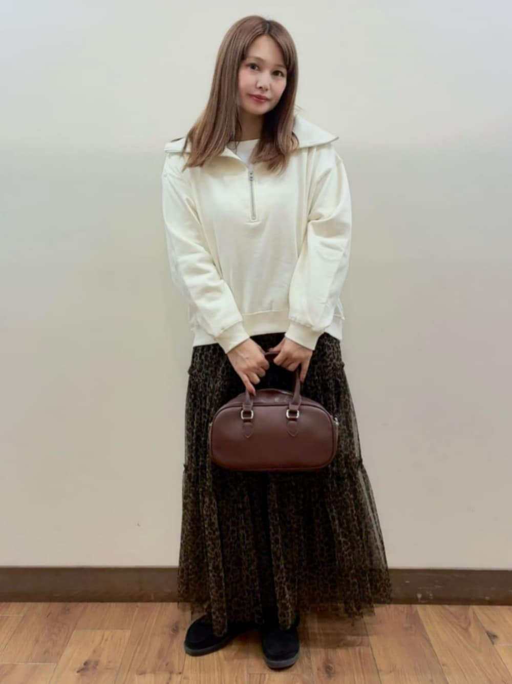 ブラウン系のショルダーバッグ、ホワイト系のスウェット、ブラウン系のスカートを着用したレディースの秋コーディネートの1枚目の写真