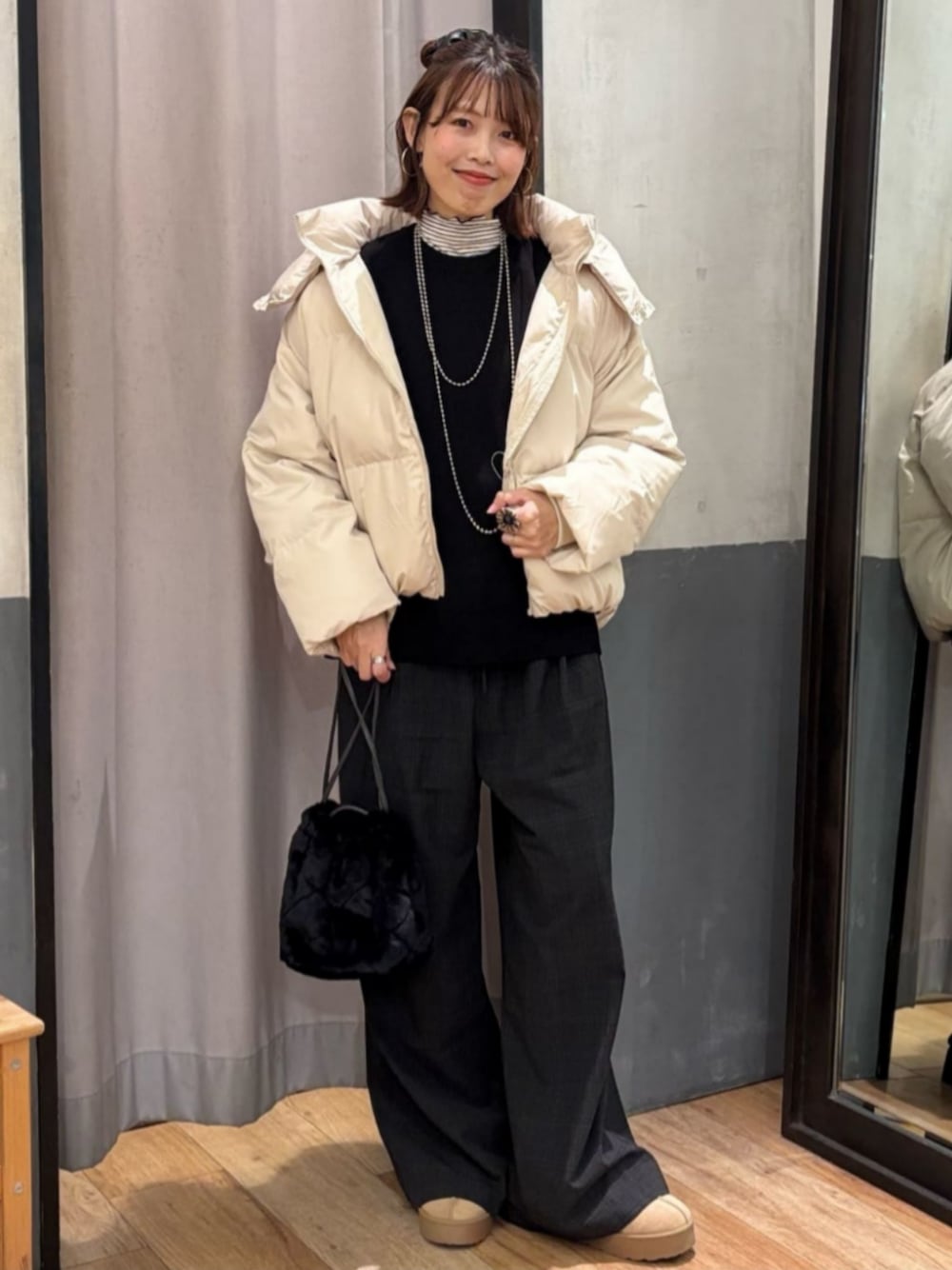 グレー系のその他パンツ、ホワイト系のダウンジャケット/コート、ブラック系のショルダーバッグを着用したレディースの冬コーディネートの1枚目の写真