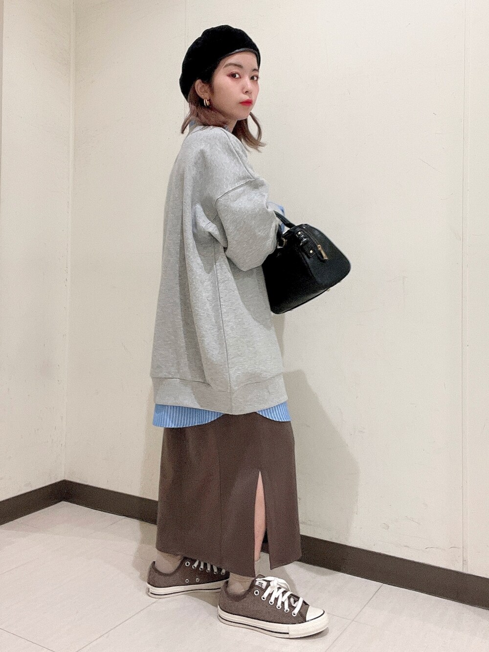 ブルー系のシャツ/ブラウス、グレー系のスウェット、ブラック系のバッグを着用したレディースの冬コーディネートの5枚目の写真