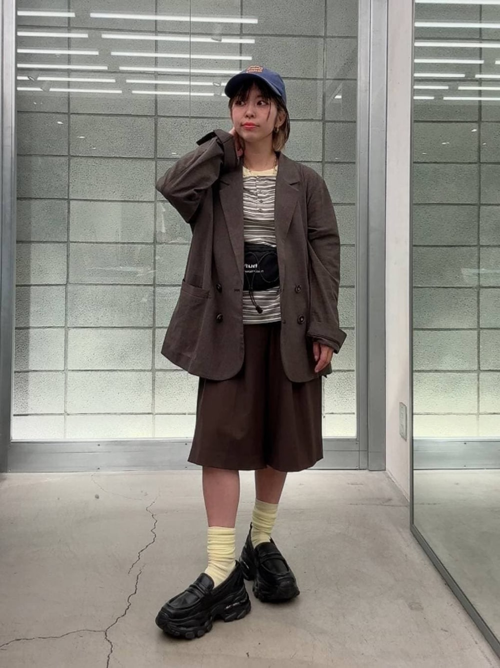 ブラック系のローファー、ホワイト系のTシャツ/カットソー、ブラウン系のスラックスを着用したレディースの春コーディネートの1枚目の写真