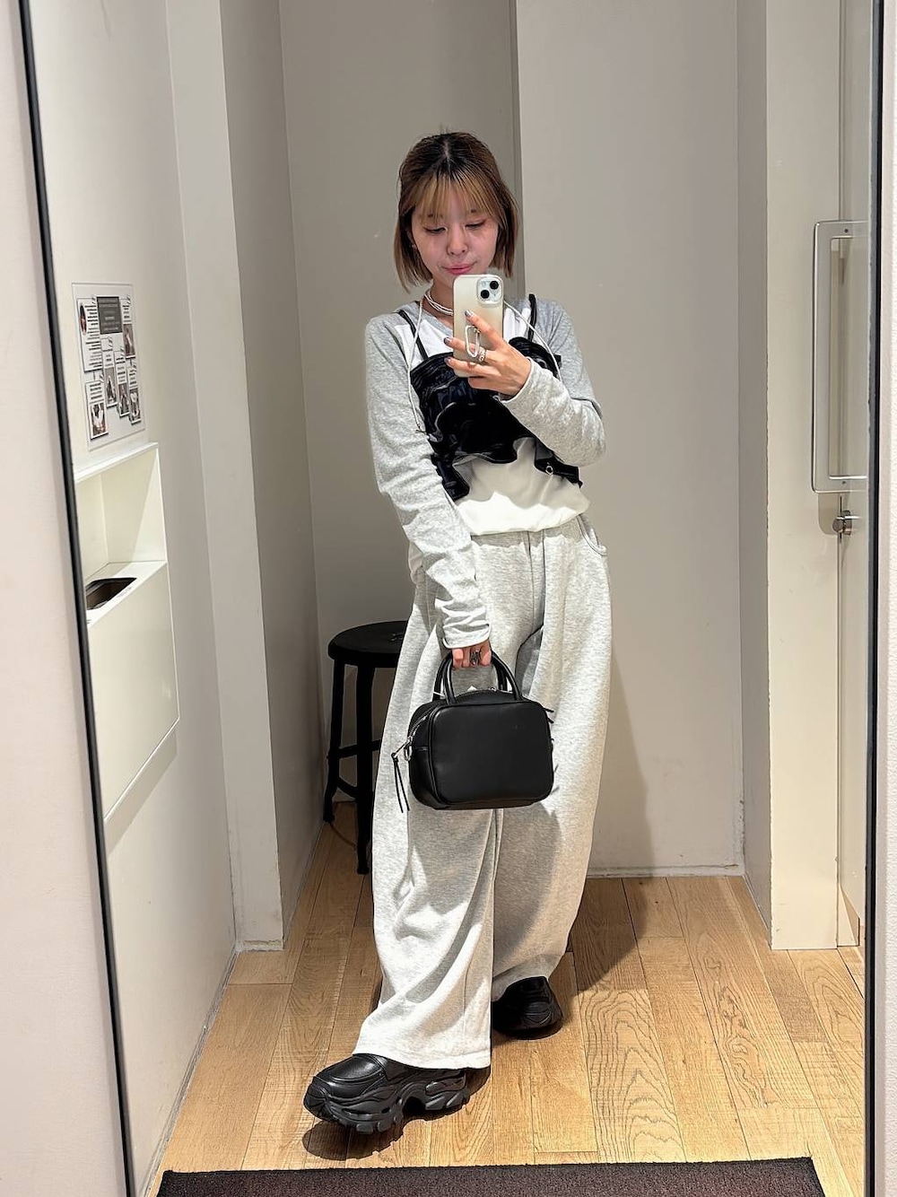 ブラック系のショルダーバッグ、グレー系のスウェットパンツ、ブラック系のローファーを着用したレディースの秋コーディネートの1枚目の写真