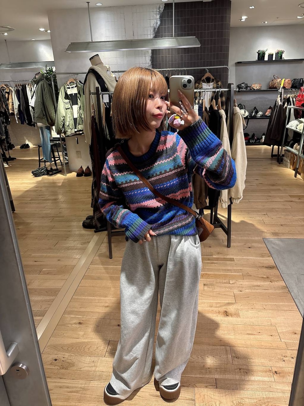 グレー系のスウェットパンツ、ブラウン系のボストンバッグ、その他のニット/セーターを着用したレディースの秋コーディネートの1枚目の写真