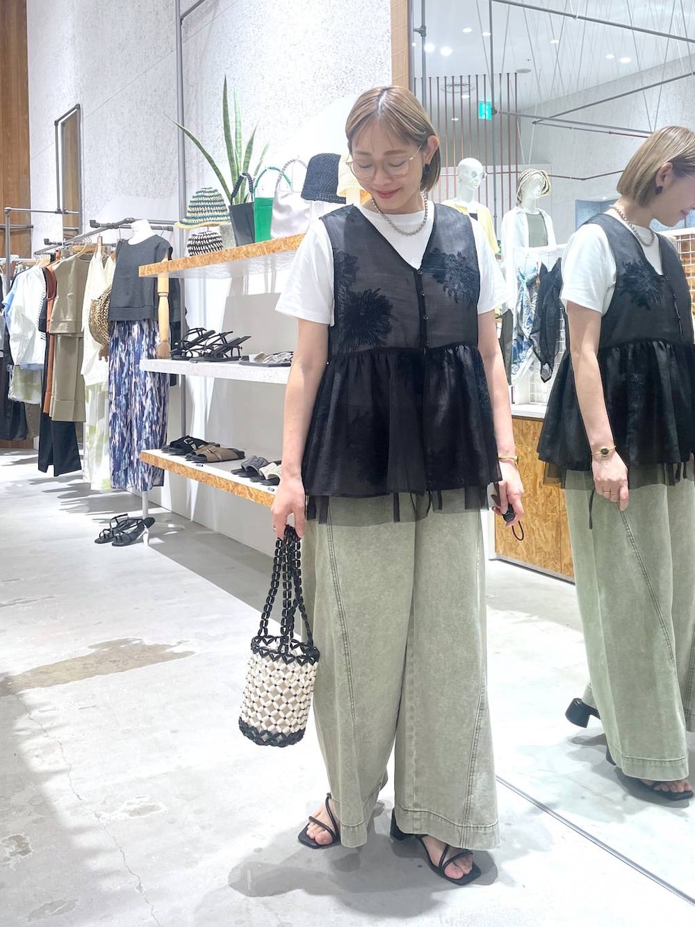 ホワイト系のTシャツ/カットソー、グリーン系のデニムパンツ、ブラック系のサンダルを着用したレディースの夏コーディネートの1枚目の写真